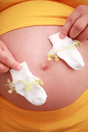  pregnant woman holding baby socksの写真素材