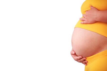 pregnant woman in yellow knitwere isolatedの写真素材