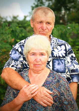 Sad senior couple embracing outdoorsの写真素材