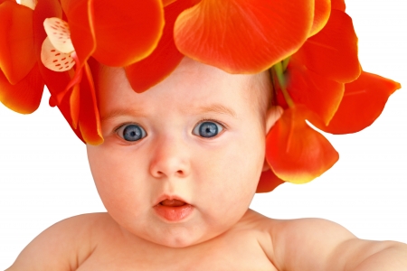 Cute baby girl with flowers looking at cameraの写真素材