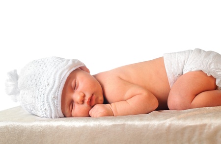 sleeping newborn baby girl in white hat wearing diaperの写真素材