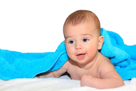 Cute baby boy lying down covered with blue towel close upの写真素材