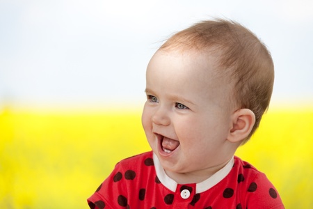 laughing cute baby girl in summer close upの写真素材