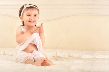 Cute Baby girl sit in bedの写真素材