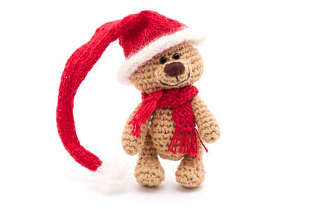 tiny knitted teddy bear in a red Christmas hatの写真素材
