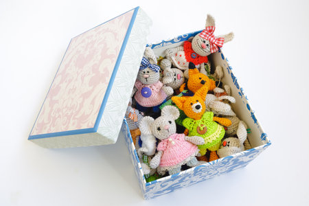 Tiny crochet toys in a decorative cardboard box on a white backgroundの写真素材