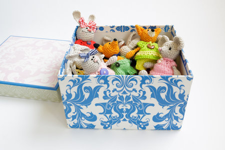Tiny crochet toys in a decorative cardboard box on a white backgroundの写真素材