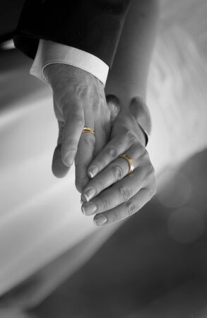 Wedding gold rings fit on hands`s bride and groomの写真素材