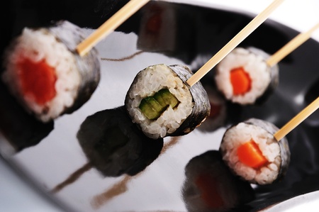 Sushi on sticks  in  a black plate.の写真素材