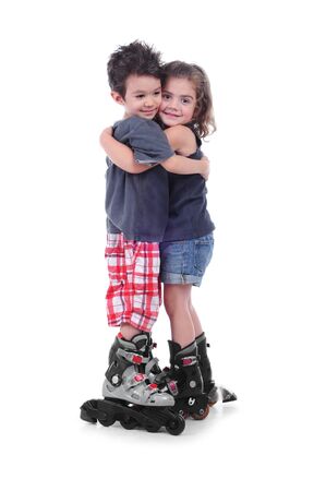 Cute boy and girl 4 years  with roller skating hug themself in a studio on white backgroundの写真素材