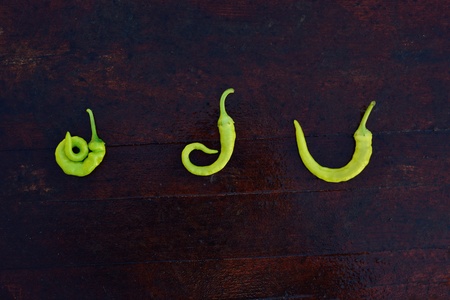 Bio curved green  peppers on a wood texture arranged  in composition の写真素材