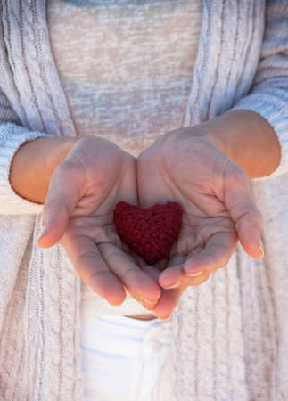 young girl holding a heart in his handsの写真素材