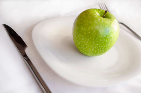 green Apple is on the plate, the concept of the idea of diet and healthy lifestyleの写真素材