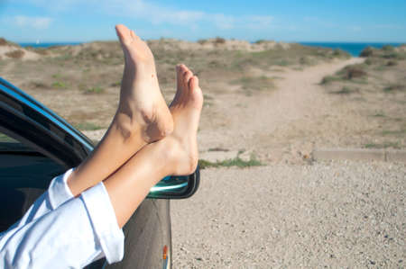 summer vacation at the sea, the woman hanging their legs out the car windowの写真素材