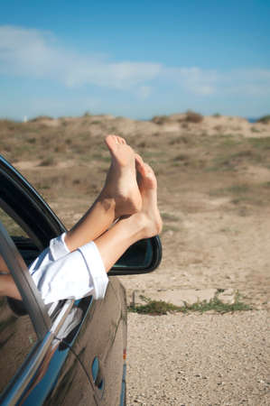summer vacation at the sea, the woman hanging their legs out the car windowの写真素材