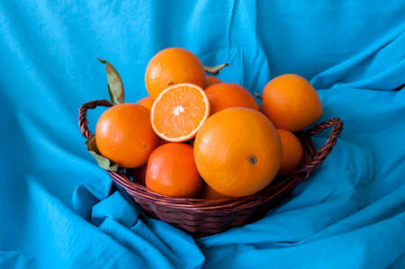 ripe orange fruits in bulk on the blue tablecloth