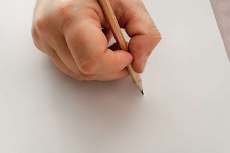 in his hand a pencil, a blank sheet of paper ready to drawの写真素材
