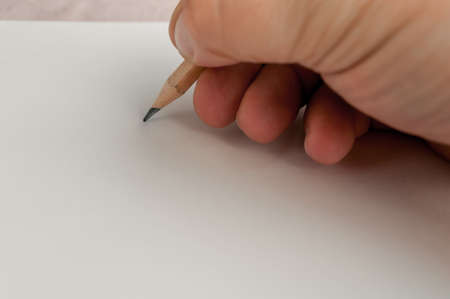 in his hand a pencil, a blank sheet of paper ready to drawの写真素材