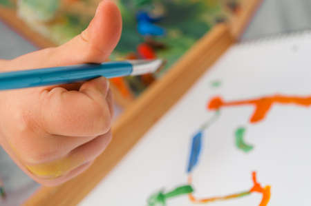 the child draws oil paint on canvasの写真素材