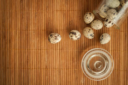 quail eggs in a decorative glass jar on the tableの写真素材