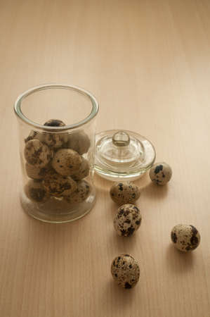 quail eggs in a decorative glass jar on the tableの写真素材