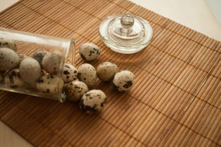 quail eggs in a decorative glass jar on the tableの写真素材
