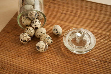 quail eggs in a decorative glass jar on the tableの写真素材