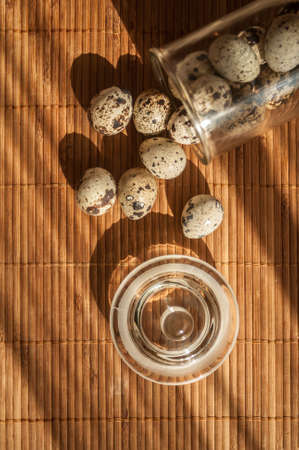 quail eggs in a decorative glass jar on the table in the sunの写真素材
