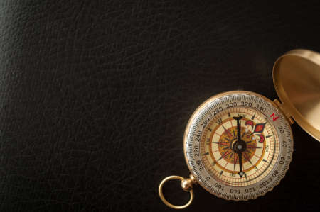 gold plated old compass on black leatherの写真素材