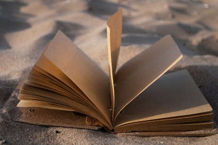 open the notebook in the sand closeupの写真素材