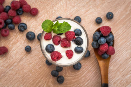 tender, delicious, diet white yogurt with raspberries and blueberries on the tableの写真素材