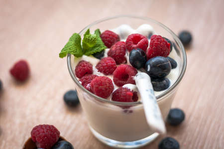 tender, delicious, diet white yogurt with raspberries and blueberries on the tableの写真素材