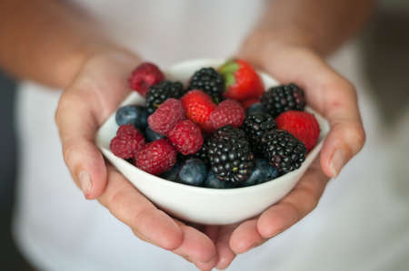 the girl offers diet vegenarian and healthy Breakfast yogurt with berriesの写真素材