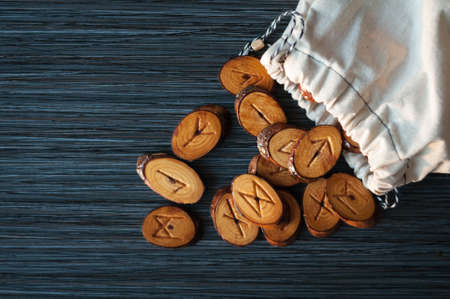 on a dark background from the rag bag spilled a few wooden runesの写真素材