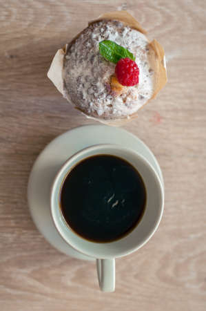 Black aromatic coffee with a fresh muffin and raspberries for Breakfastの写真素材
