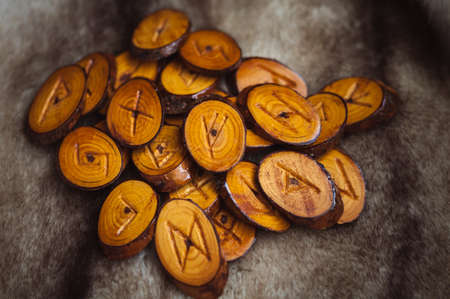 wood runes handmade fur are lying beside the crystal ball and semi-precious stonesの写真素材