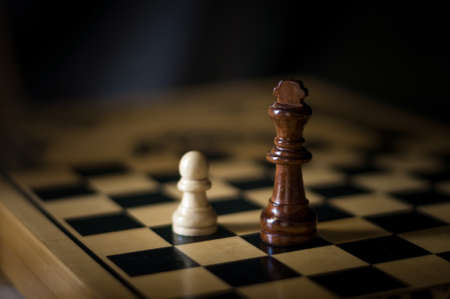white pawn and black king on chessboardの写真素材