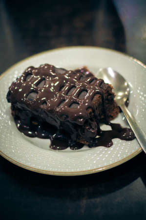 on the table Browning cake on a white plate with a spoon