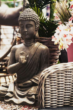 Buddha figure in the garden among the flowersの写真素材