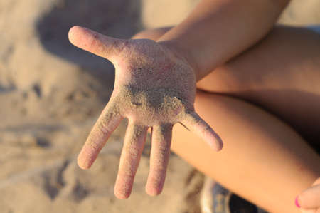 baby girls hand in the sandの写真素材