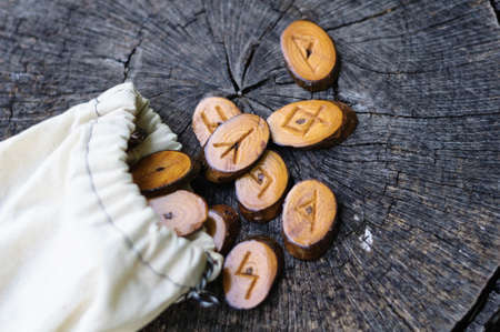 wooden runes in a bag on an old stumpの写真素材