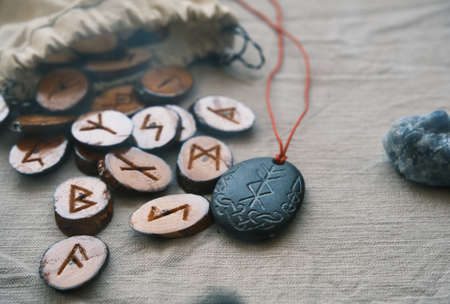 wooden runes in a canvas bag with a stone runescriptの写真素材