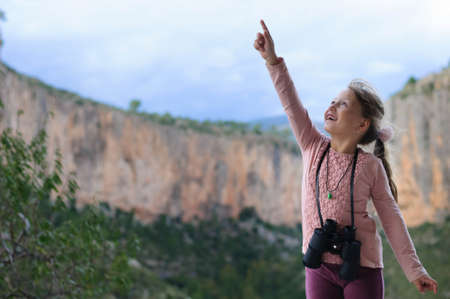 girl with binoculars on the background of the mountainの写真素材