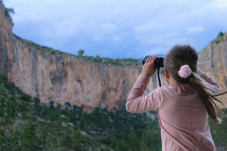 girl with binoculars on the background of the mountainの写真素材