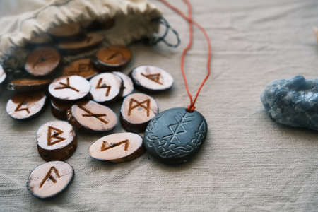 wooden runes in a canvas bag with a stone runescriptの写真素材