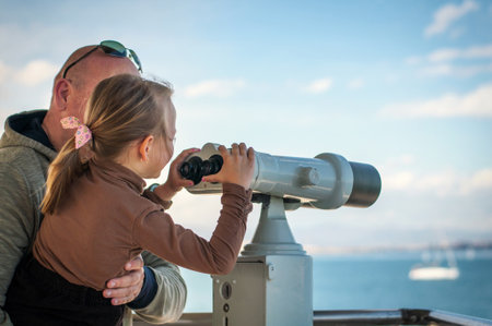 a father and his daughter are seen in public through binocularsのeditorial素材