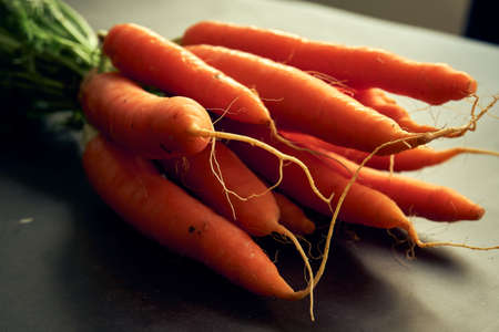 bunch of clean young carrots with topsの写真素材