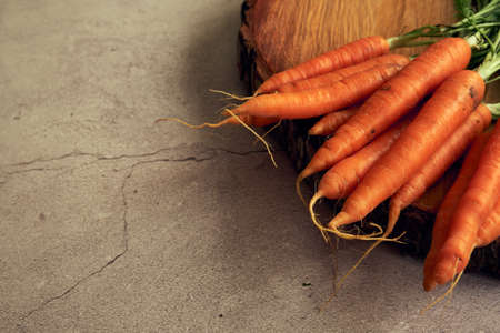 a bunch of clean young carrots on a wooden standの写真素材