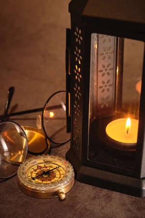 candle lamp and vintage compass on the tableの写真素材