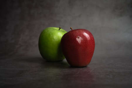 green and red apple on dark backgroundの写真素材